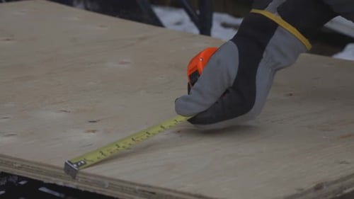 Measuring The Height Of The Wood Plank Using A Tape Measure. -medium shot
