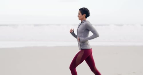4k video footage of an attractive young sportswoman running on the beach