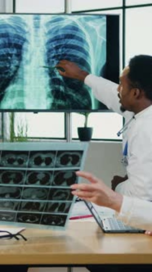 Doctors Discussing X-Ray Scan in Hospital Room