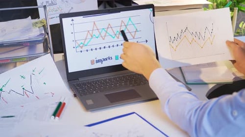 Man Analyzing Charts in Office Workplace