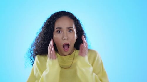 Wow, surprise and face of woman in studio shocked by news, gossip or drama on blue background