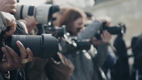 Crowd of Photographers Holding Cameras and Lenses