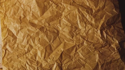 Zerknittertes Bastelpapier in warmen Braun-, Terrakotta- und Erdbräunetönen, das nacheinander geschichtet wird.