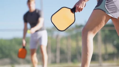 Couple Playing Pickleball Game Hitting Pickleball Yellow Ball with Paddle Outdoor Sport Leisure