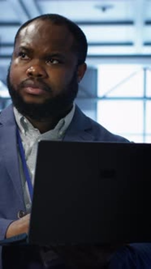 Vertical Video Computer Scientist in Data Center Using Diagnostic Tools on Laptop