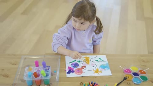 Little Girl Coloring Paper With Watercolors During Her Art Class. - close up shot