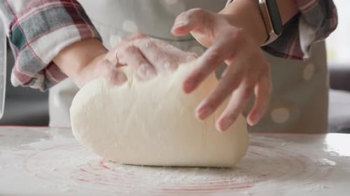 Woman kneading dough at home preparing to bake