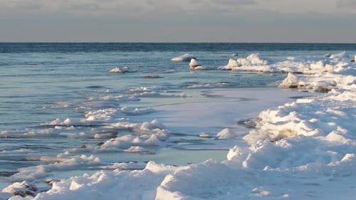 In the winter, stones are icy on the sea shore. Icicles hung from large pieces of ice