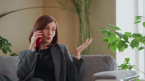 Smiling Businesswoman Talking on Phone in Modern Office with Indoor Plants