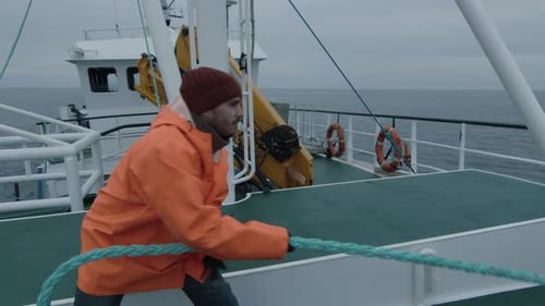 Man pulling rope on a boat on the ocean