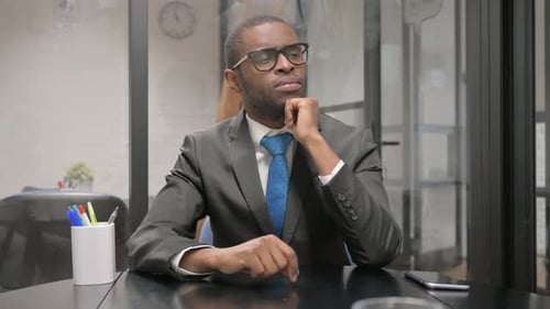 Adult Man Thinks at Office Desk