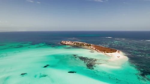 Island embraced by vibrant turquoise ocean waves
