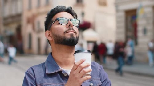 Young Indian Man Enjoying Drinking Morning Coffee Hot Drink Relaxing Taking a Break in City Street