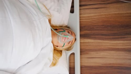Plan rapproché d'une jeune fille allongée dans une chambre d'hôpital portant un masque à oxygène pour lutter contre les maladies respiratoires
