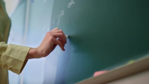 Writing with chalk on a green chalkboard