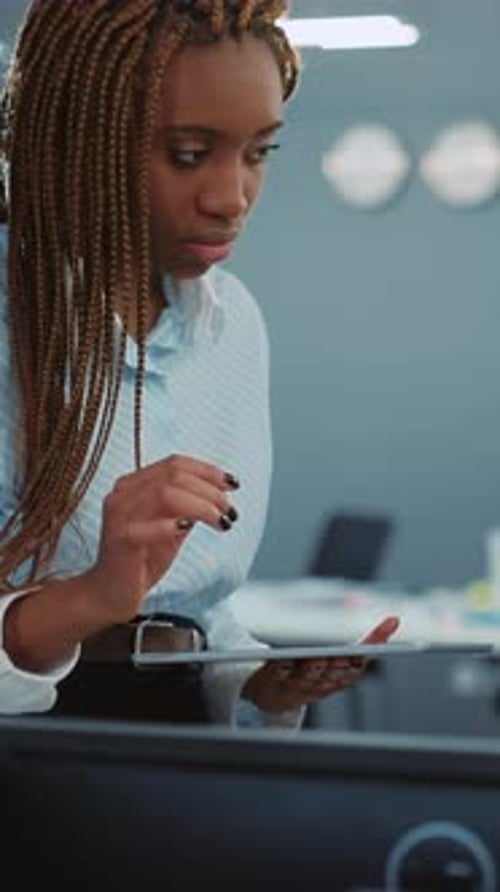 A Professional Woman Engaged Actively in a Discussion While Using a Tablet in an Office Setting