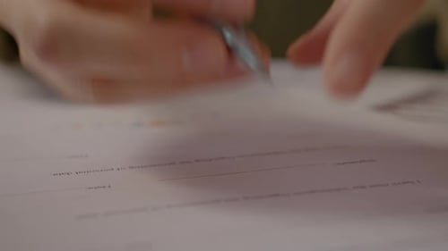 Close up of a woman signing a contract at her office workspace