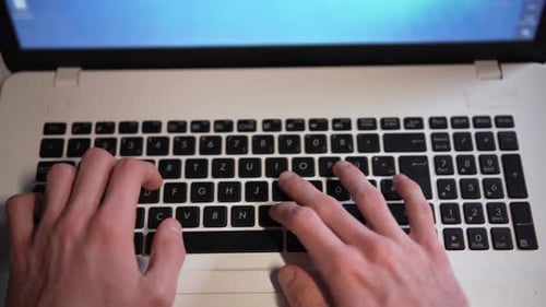 Die Männerhände tippen auf der Tastatur eines weißen Laptops Große Nahaufnahme