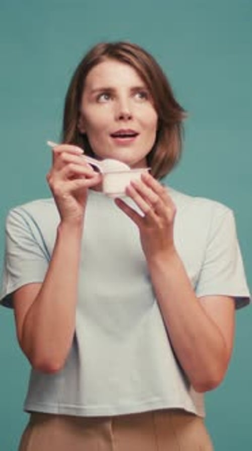 Woman enjoys eating from a small container
