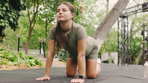 Woman Exercising with Cat Cow Pose Outdoors