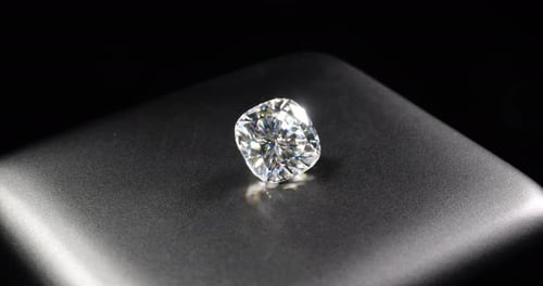 Shimmering Diamond Gemstone on Grey Surface