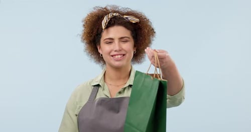 Woman, waitress and coffee with paper bag, food and smile for good service, blue studio background