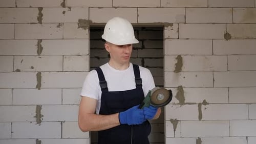 A Smiling Male Construction Worker in a White Helmet with a Working Circular Saw