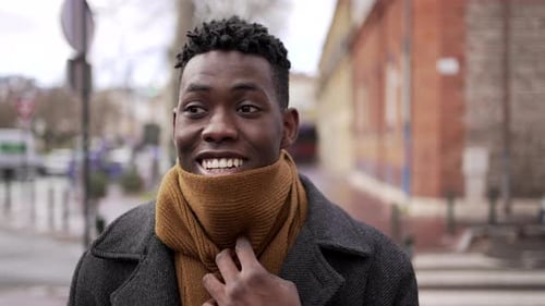 Handsome Young Man Adjusting Scarf in Urban Setting