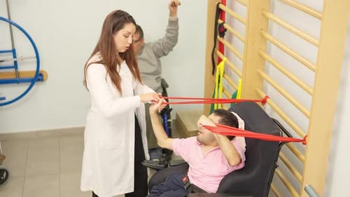 Physical Therapist Assists Man with Resistance Band Exercise