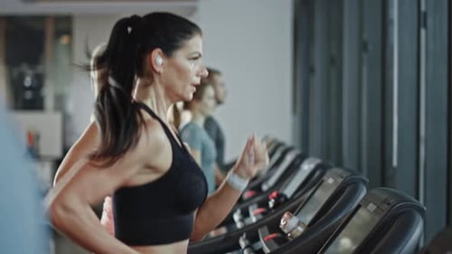 Beautiful Athletic Sports Woman Wearing Wireless Headphones, Listens to a Podcast or Sport Music Pl