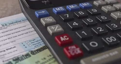 Calculator, Pen and Taxes Documents Close Up