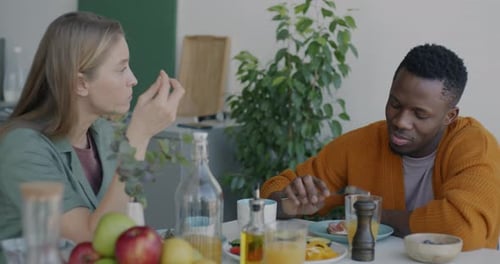 Couple Eating Breakfast and Laughing Indoors