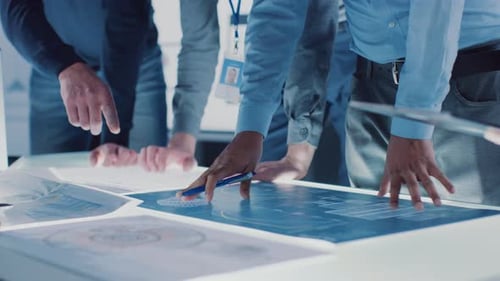 Team Collaborating on Technical Blueprints in Office