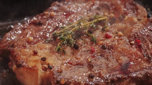 Fresh Marbled Beef with Pepper Salt and Rosemary Closeup Macro Cooking Juicy Steak on Grill with Oil