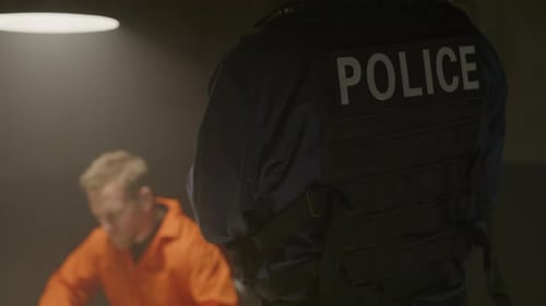 Man in Orange Jumpsuit with Police Officer