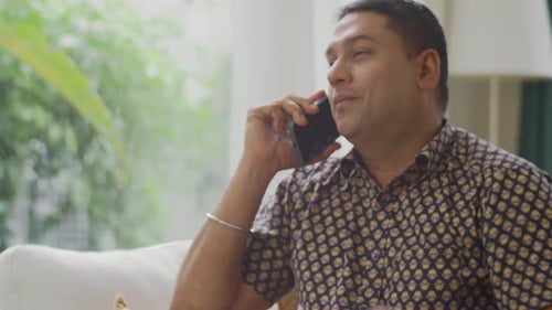 Man Talking on Phone Indoors During the Day