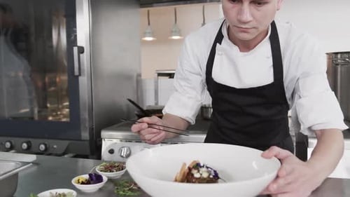 Chef Garnishing Food with Chopsticks in Commercial Kitchen