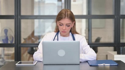 Female Doctor Typing on Laptop in Clinic