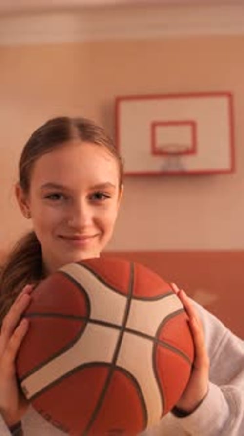 Vertical Video Young Basketball Player Holding Ball in School Gym