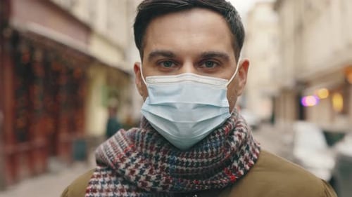 Close Up of Face of Caucasian Handsome Guy in Medical Mask Looking Straight to Camera with Happy