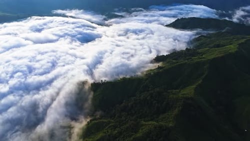 Dramatic Aerial of Clouds Rolling Over Lush Green Mountain Peaks
