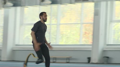 Man with Prosthetic Leg Runs on Indoor Track