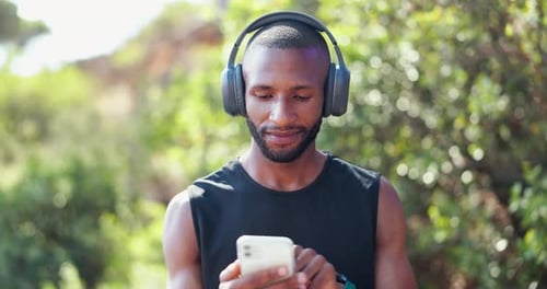 Man Listens to Music, Uses Mobile Phone in Park