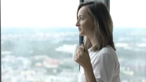Woman Drinking Coffee And Admire View Form Window At Home