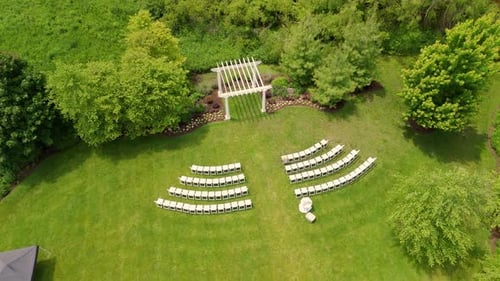 Top Down Aerial View of the Outdoor White Wooden Arch The Setting is on a Grassy Area Surrounded By