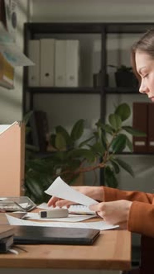 Female Office Employee Stapling Paper Documents