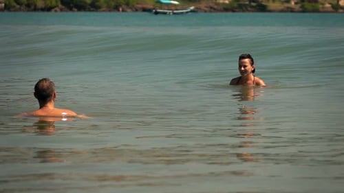 Young couple relaxing in the sea on summer vacations super slow motion