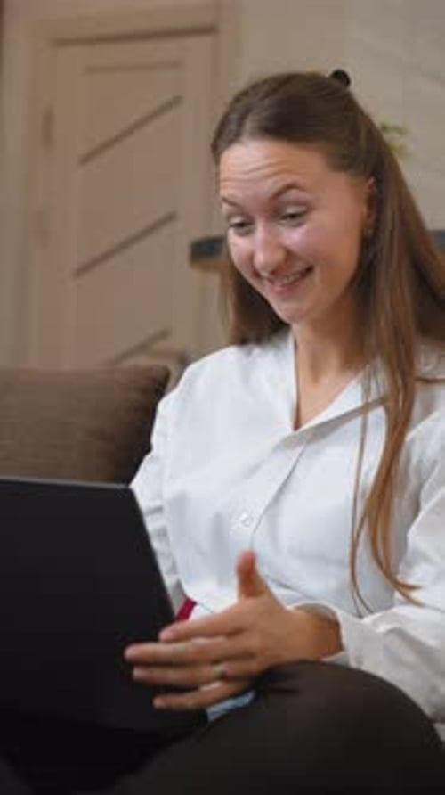 Young Adult Video Conferencing on Laptop at Home