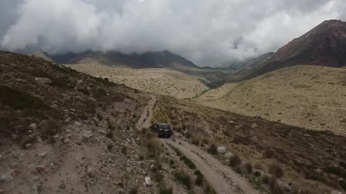 Drone: flies behind a car through a gorge in the mountains of Kyrgyzstan