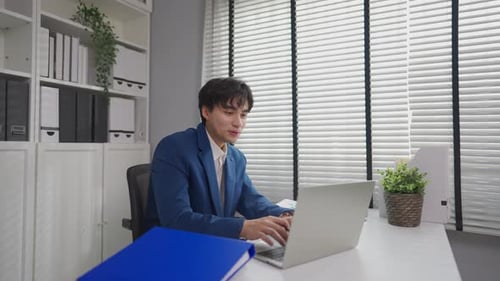 Asian attractive businessman employee working in the office workplace.
